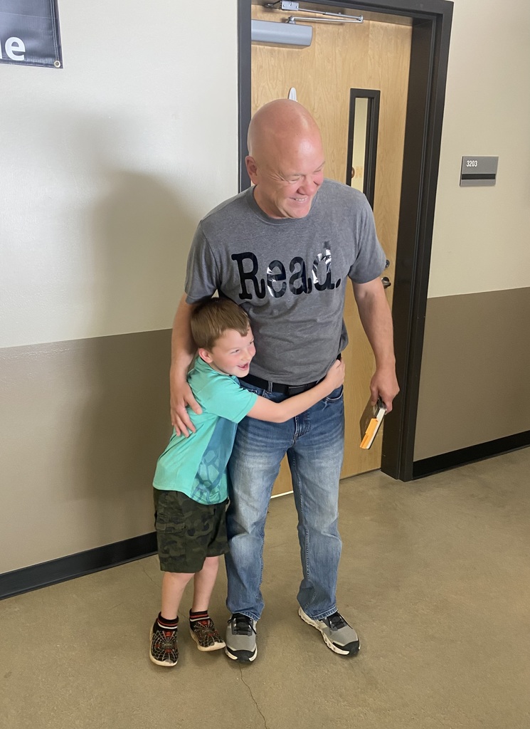 little boy hugging a bald man