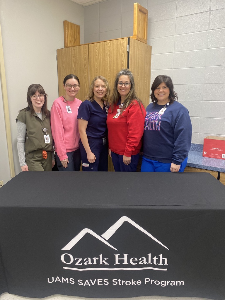 a picture of 5 women standing behind a table.