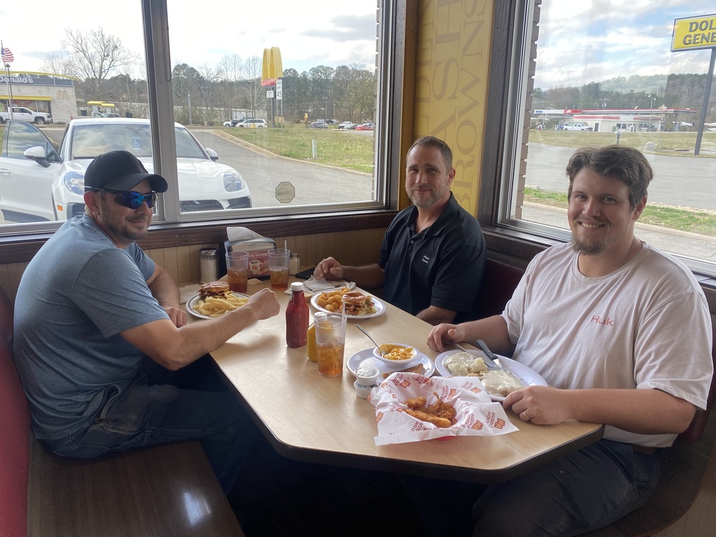 3 men sitting at a table eating lunch
