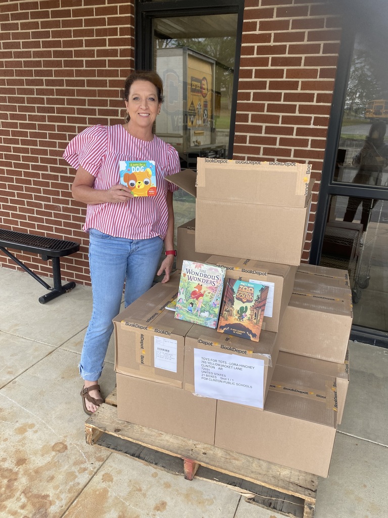 a woman holding a book standing by boxes
