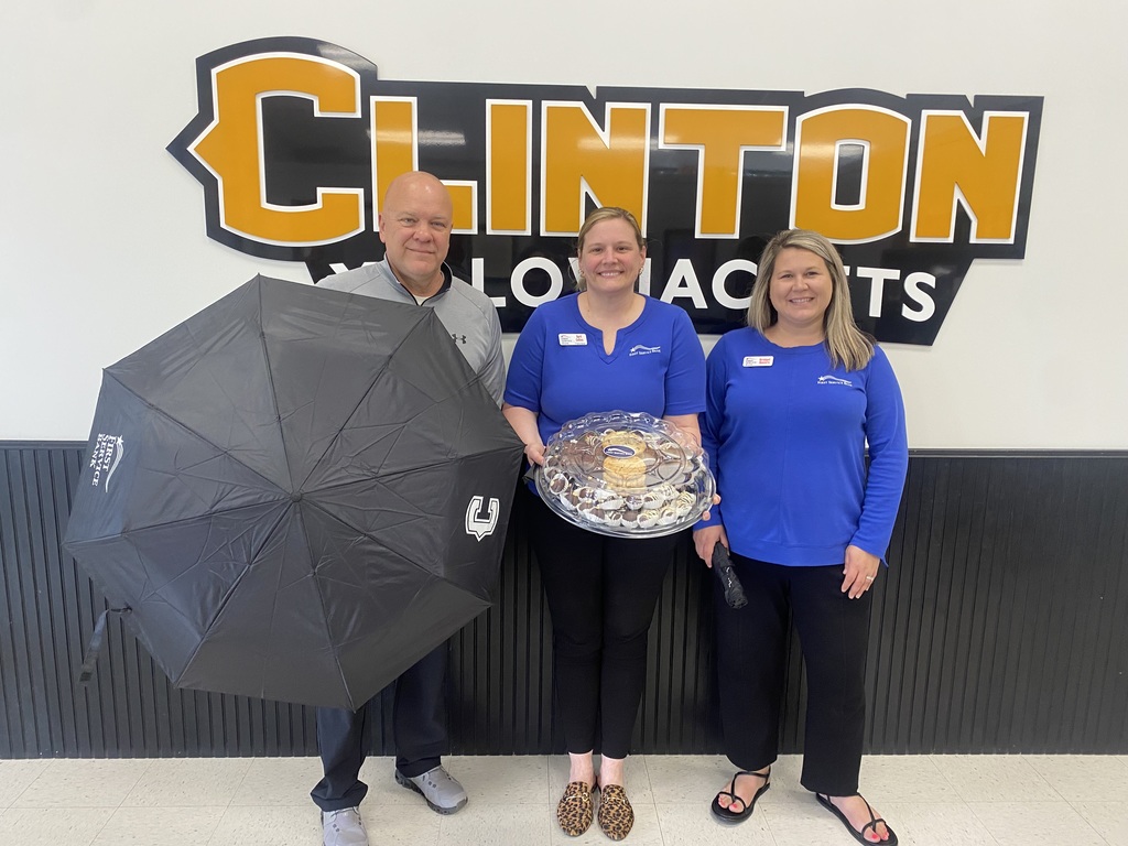 2 women and a man standing woman holding dessert tray man holding an umbrella