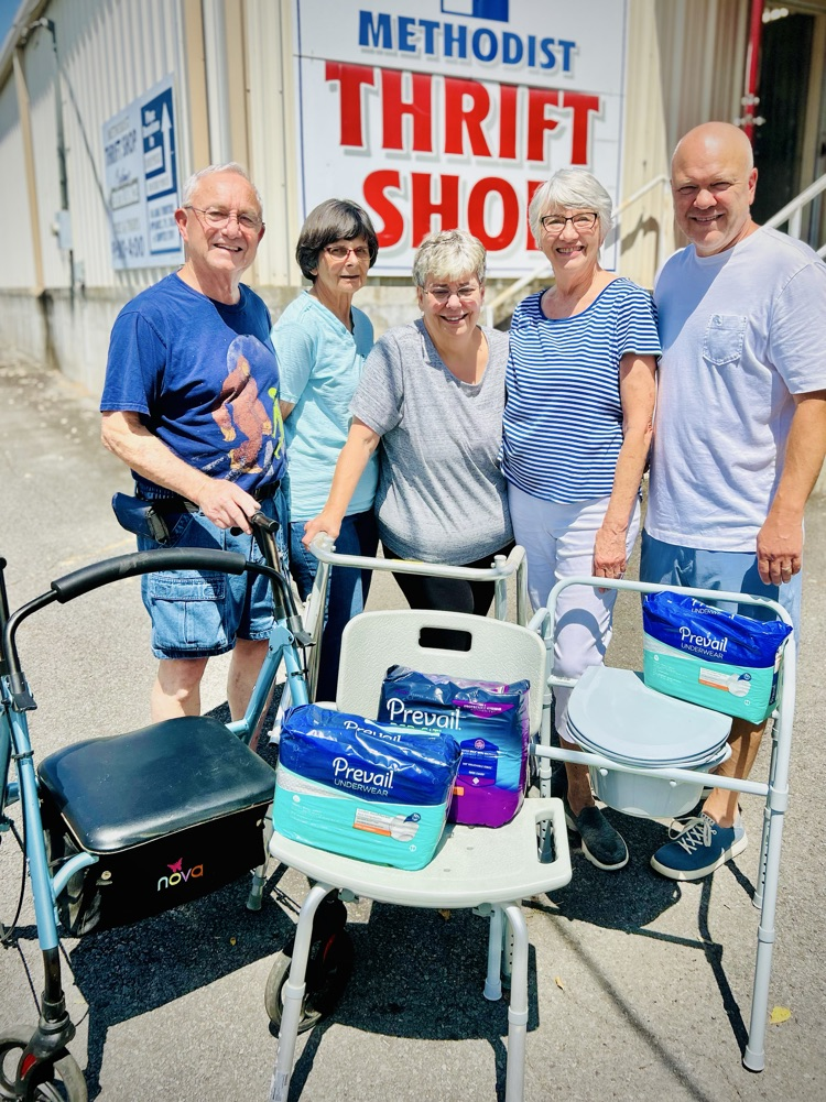 four people standing by medical equipment