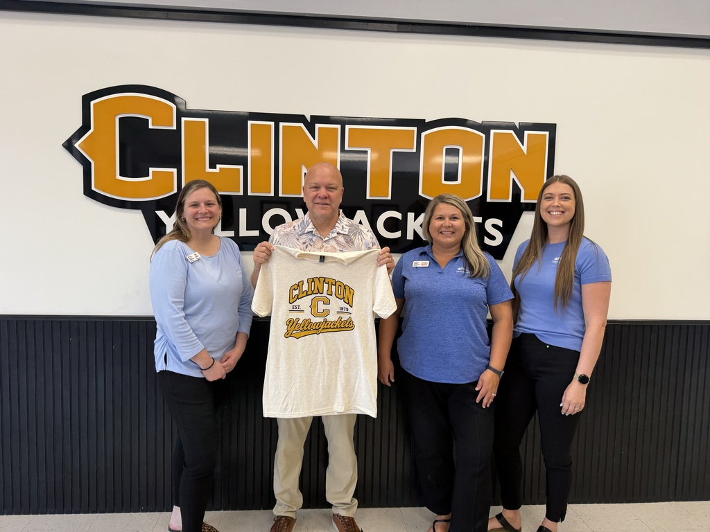 3 women and a man standing holding a tshirt