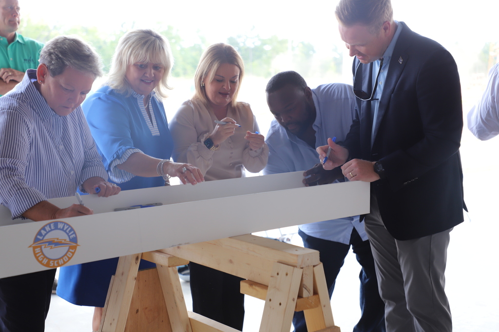 Board members signing beam