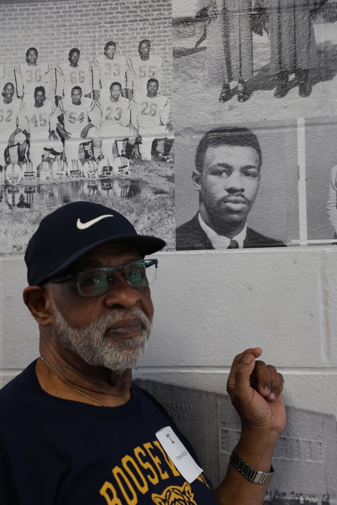 Alumnus with picture on wall
