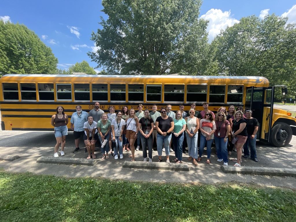 New staff standing in front of a school bus