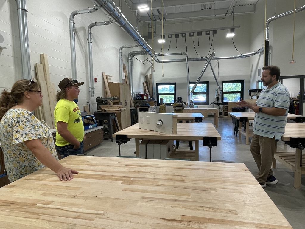 Mr. Valent showing the high school wood shopt to a family