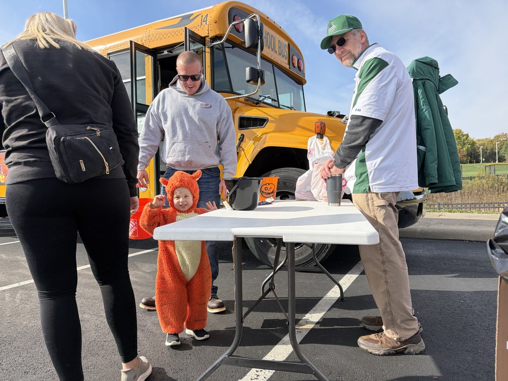 Boy in costume in front of a school bus