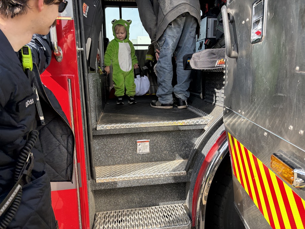 Child in costume inside fire truck