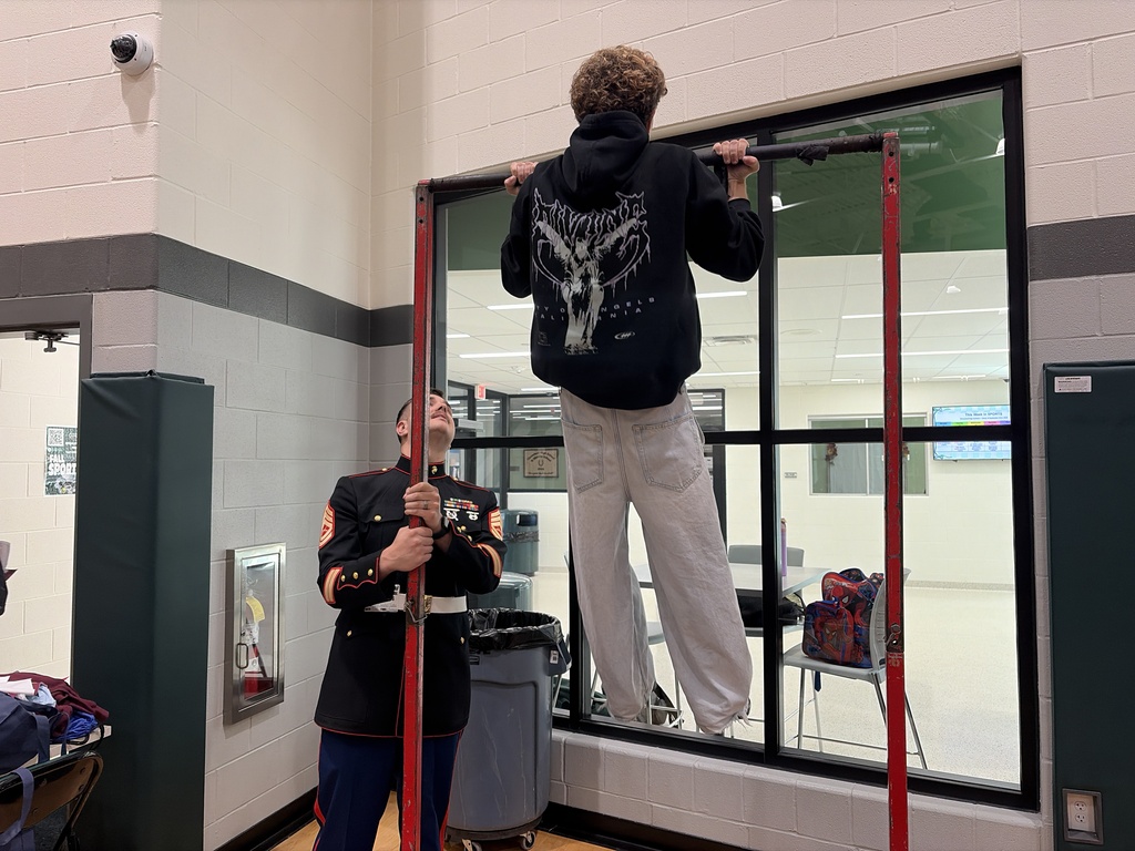 Marine recruiter with student doing pull-ups