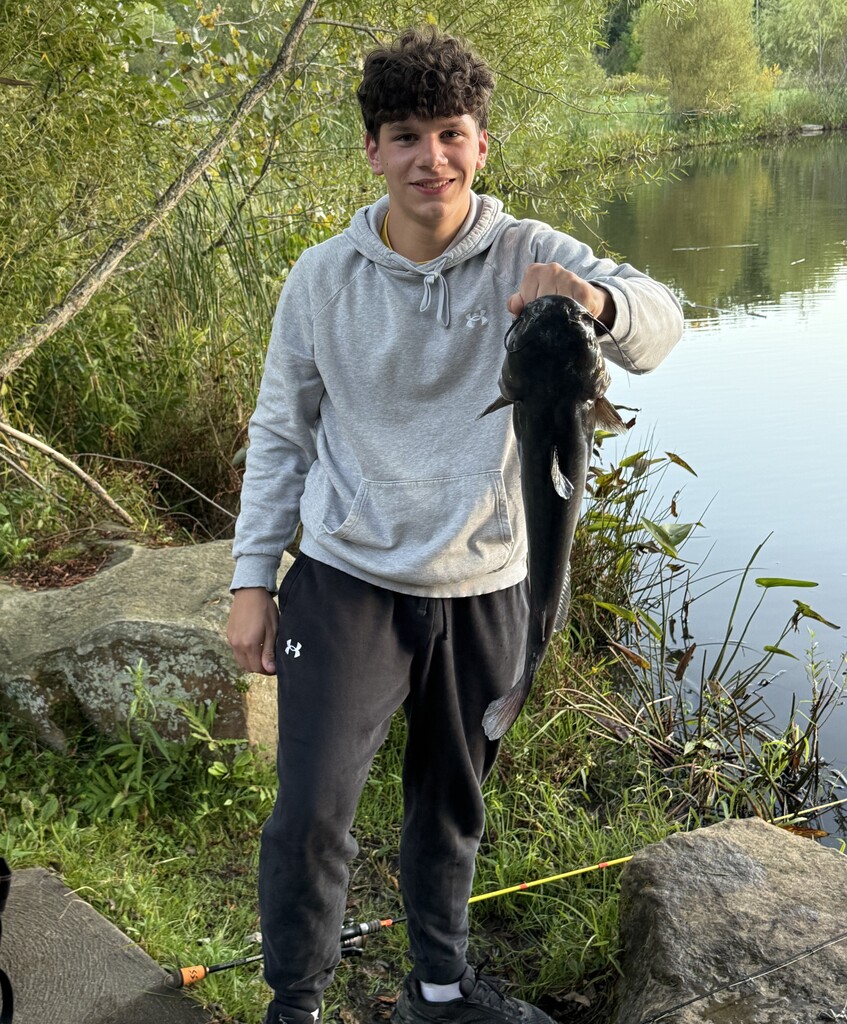 Student fisherman holding a large catfish