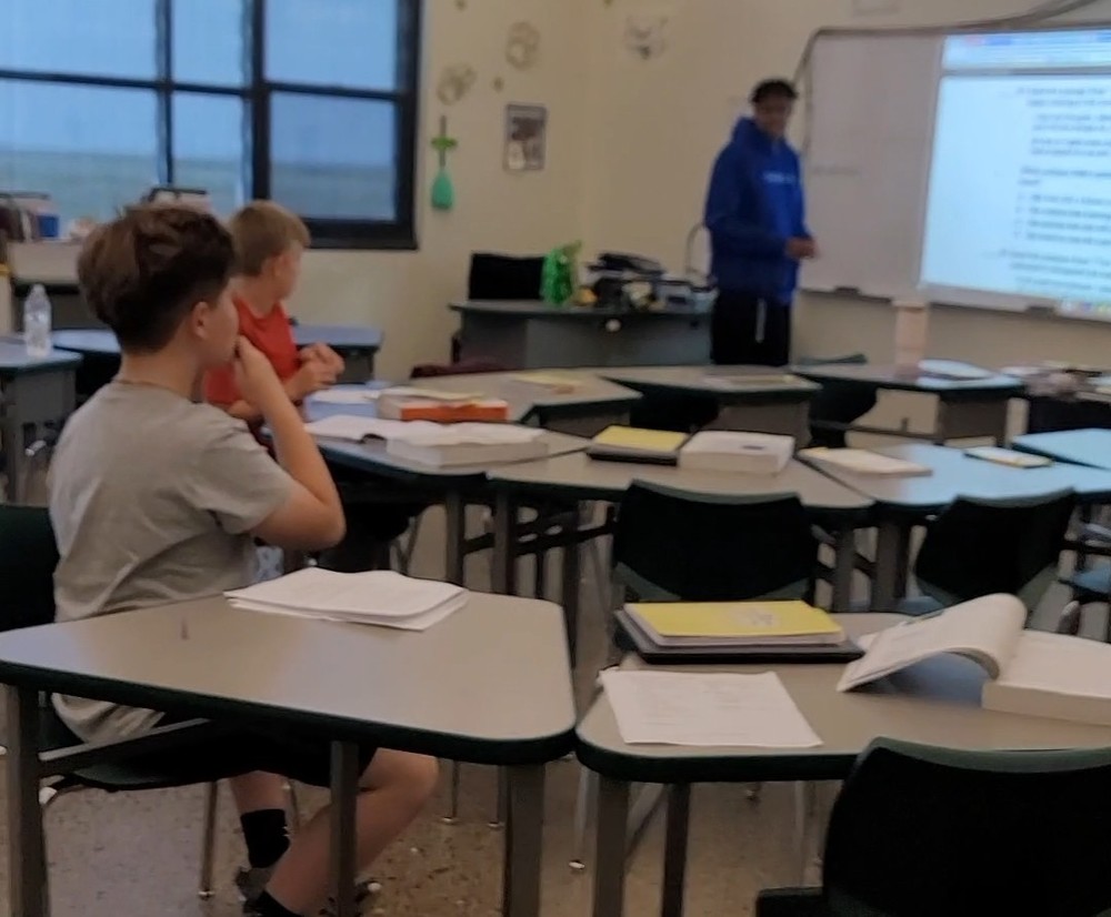 Students listen as another student teaches the class