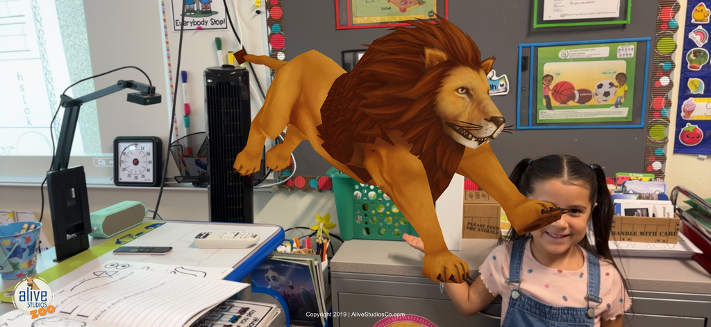 A young female students holds up an image of a lion.