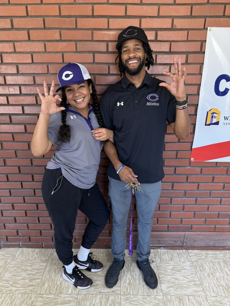 Twin Teachers holding up the wildcat hand sign.