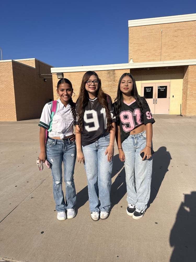 Three students wearing jerseys