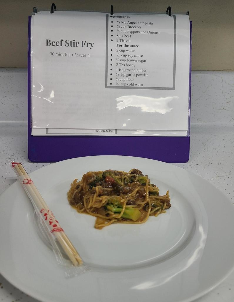 A plate of noodles and a pair of chopsticks