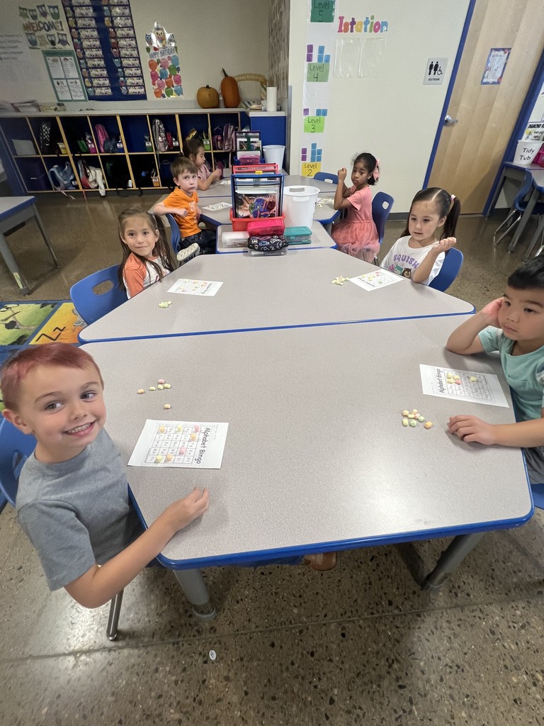 A table of kindergarten students working on assignments.