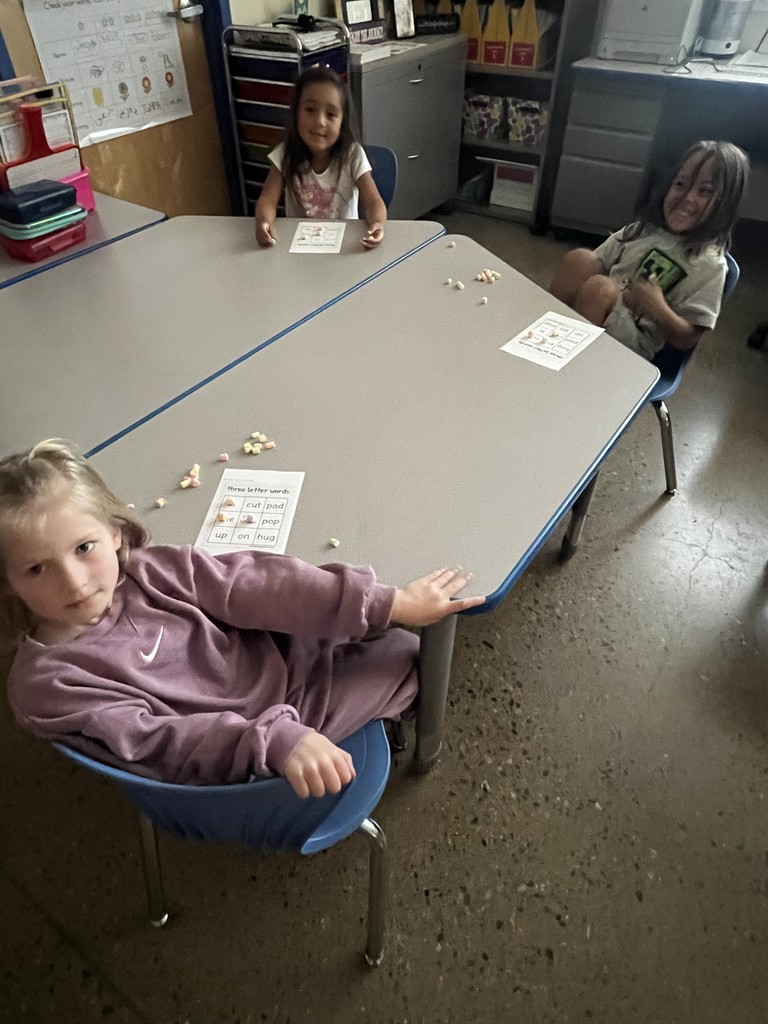 3 kindergarten students looking at the cameras