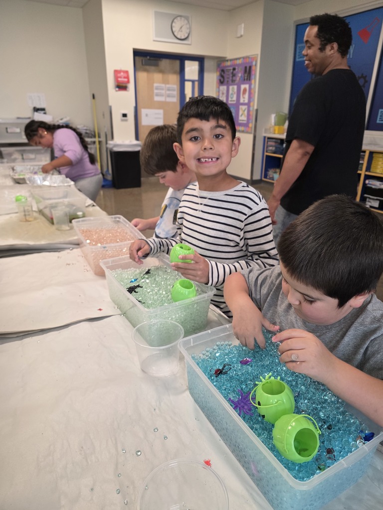 Student smiling while playing in sensory bin.