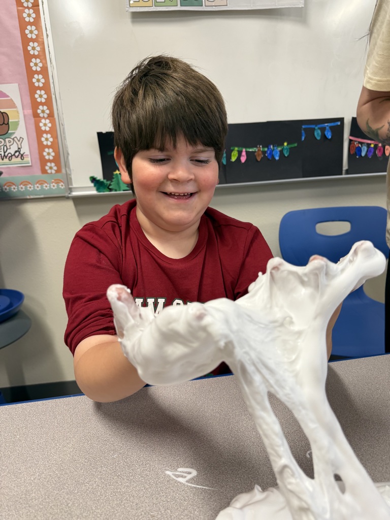 student smiling while he stretches out slime
