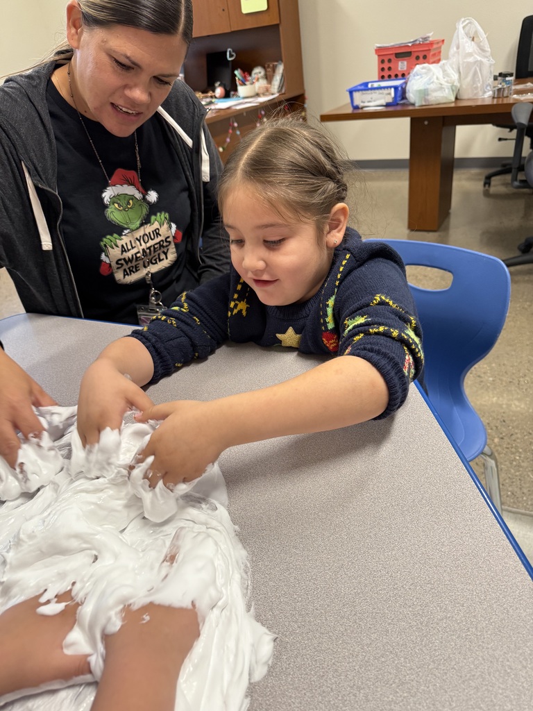 A student making slime with the assistance of Ms. LaTasha