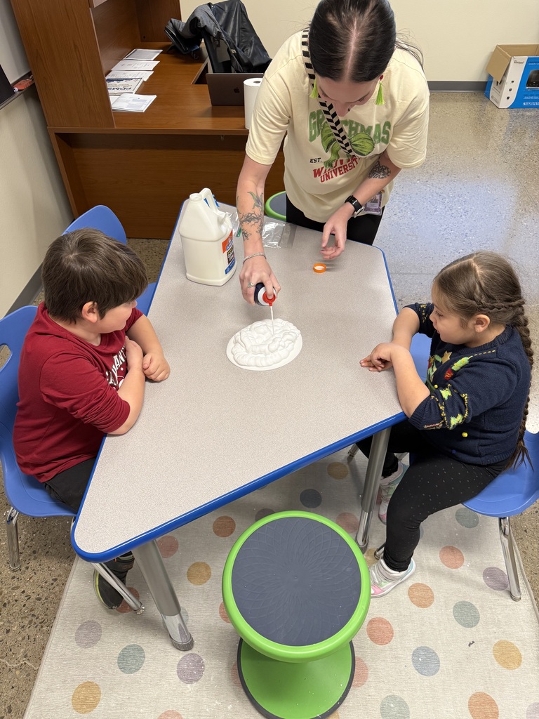 students watching Mrs. Clark add ingredients for slime.