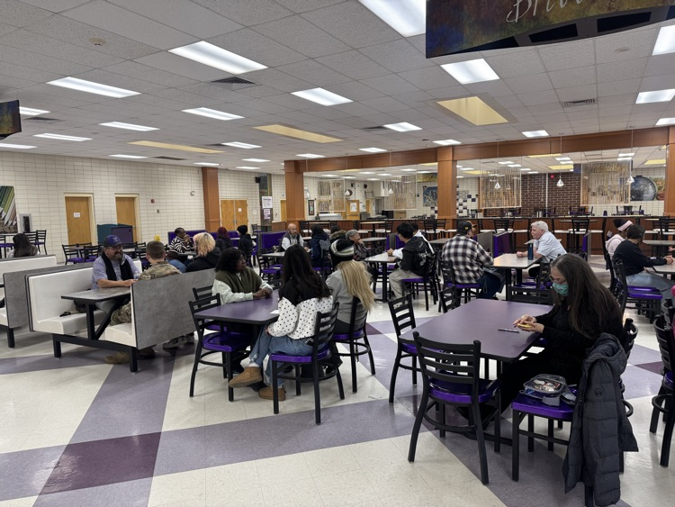 Students and community members sitting at a table. 