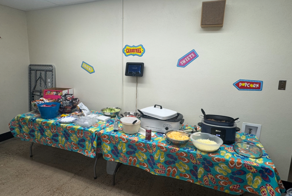 A room with two tables. Each table has various food items including casseroles, salads, and bowls.