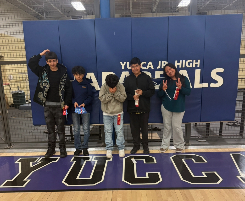 Five people stand on a court. Four hold awards. A banner behind them reads "Yucai Jr. High."