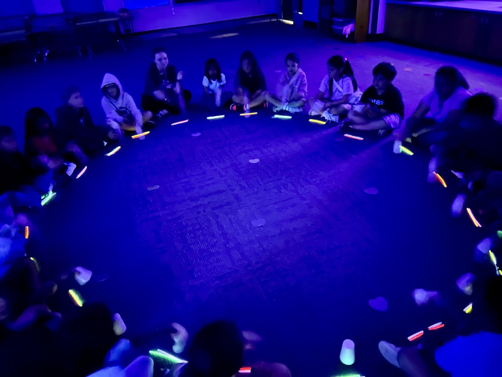 students in a glow drum circle