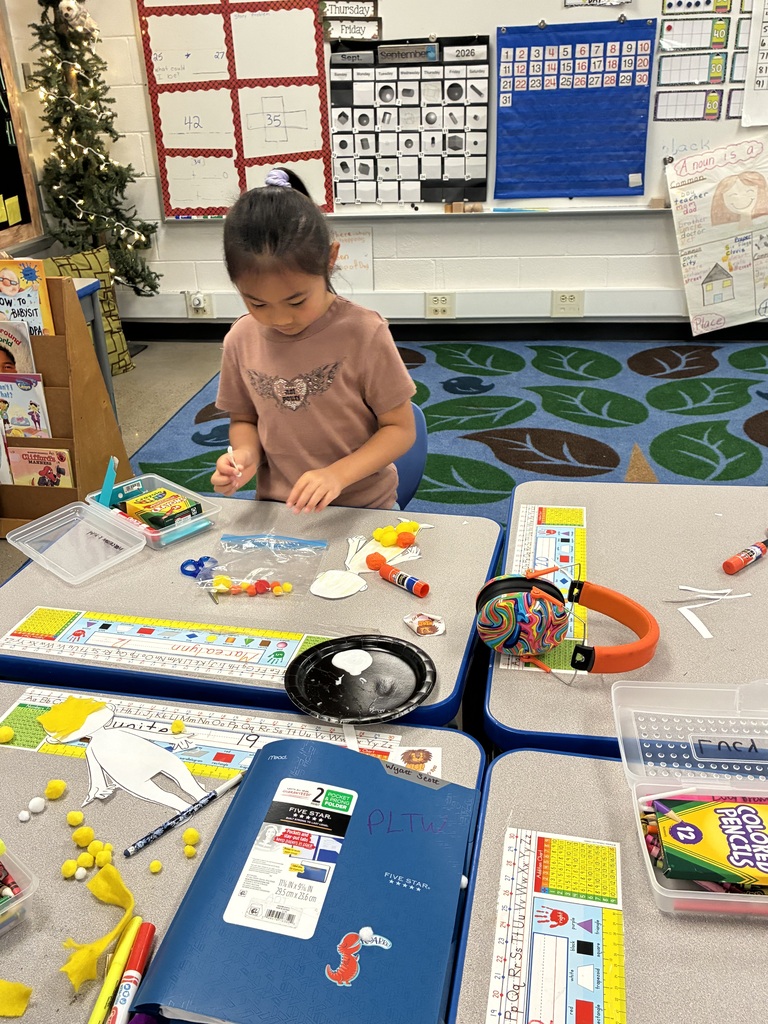 Child sitting at a desk surrounded by art supplies, including markers and colored pencils.