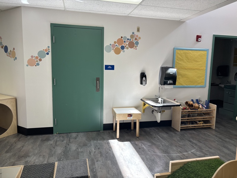 Classroom play area with shelf for toys and a sink