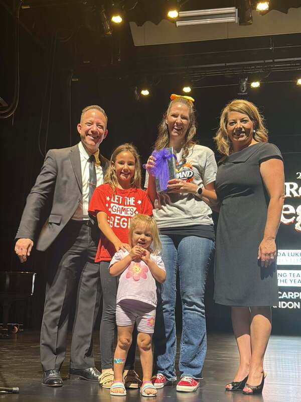 Christina Dukes and Family holding award