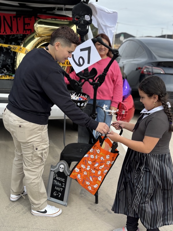6 7 trunk passing out candy to girl student dressed as Wednesday