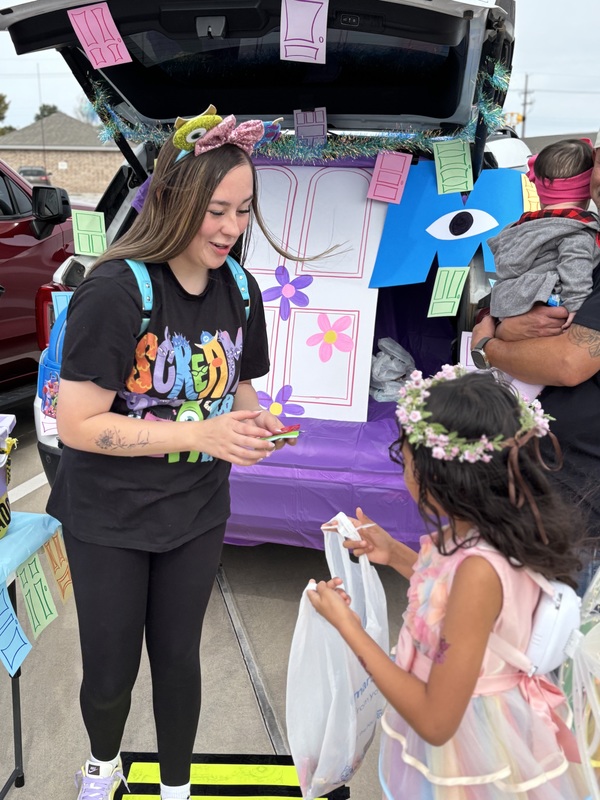 Lady handing candy to a student