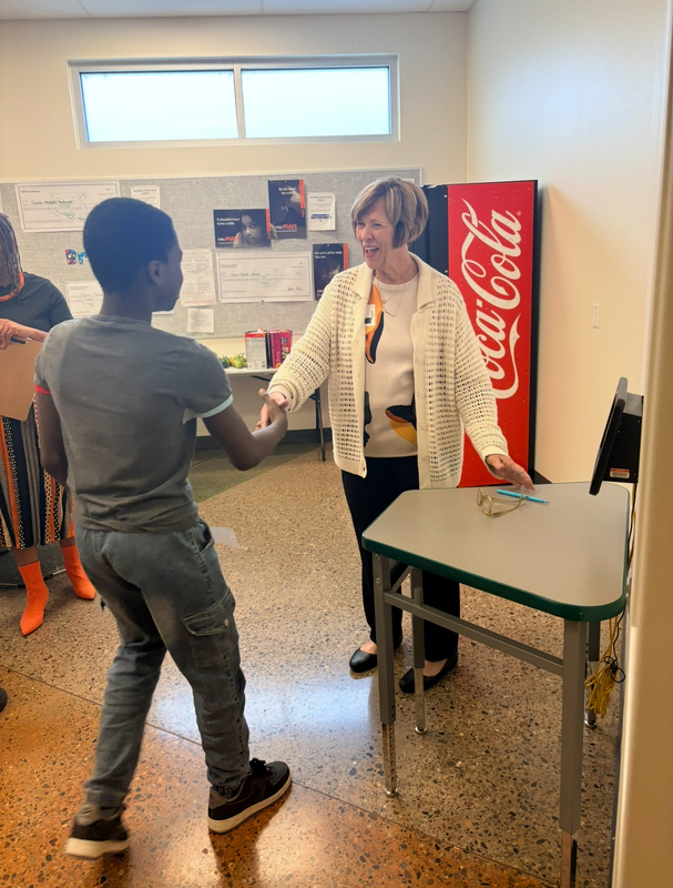 A Gattis student shakes hands with a community volunteer during round one of the Amazing Shake.