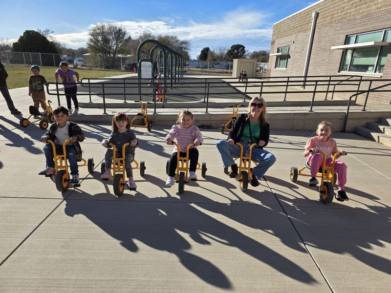 students and principal sitting on tricycle