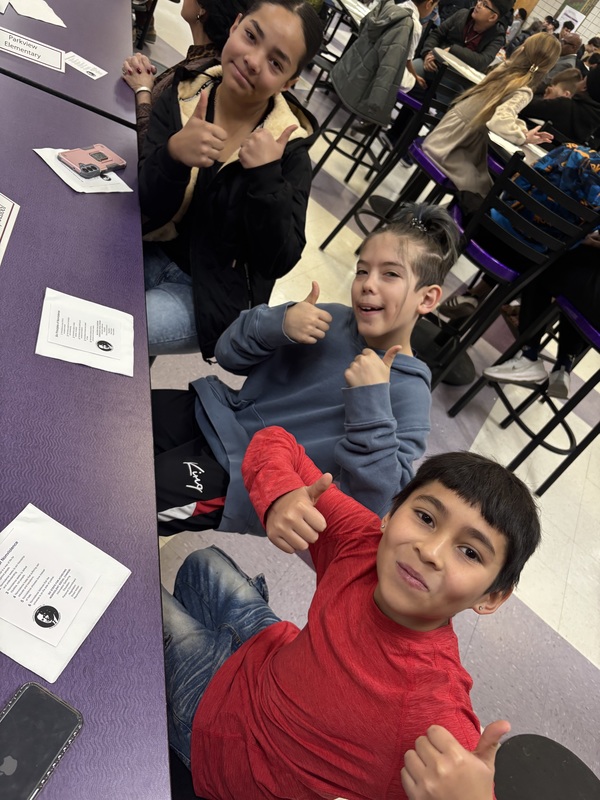 3 students smiling and holding thumbs up