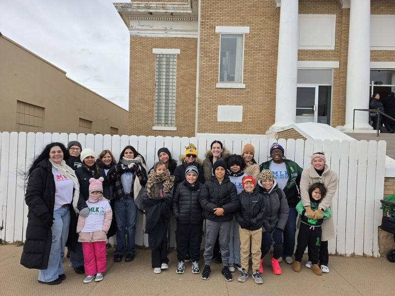 A group of adults and children in front of a church.