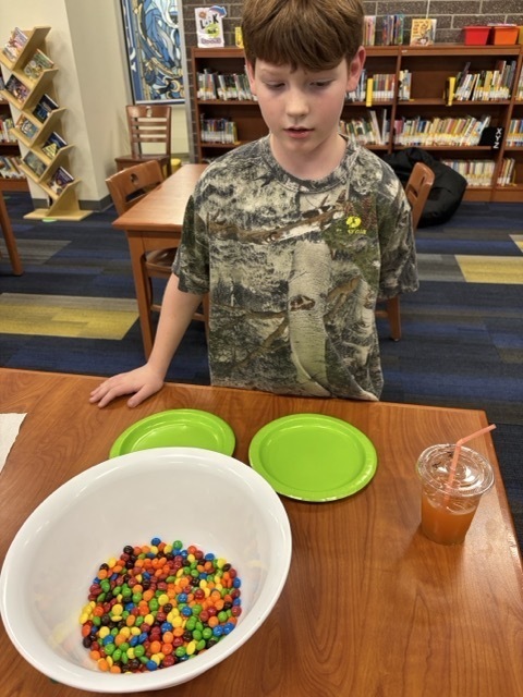 Student in front of a bowl with skittles and m&m's