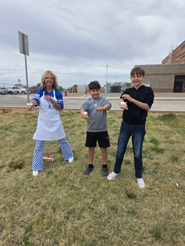 1 adult and 2 students. Each has whipped cream on the back of their hands