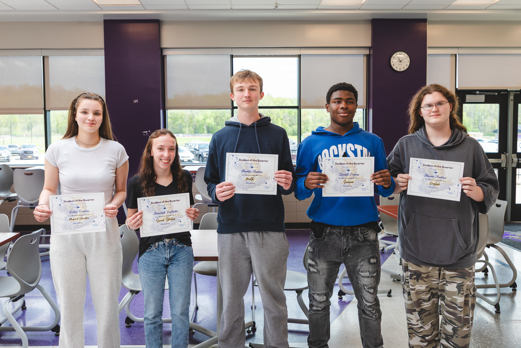 students posing with certificates of achievement