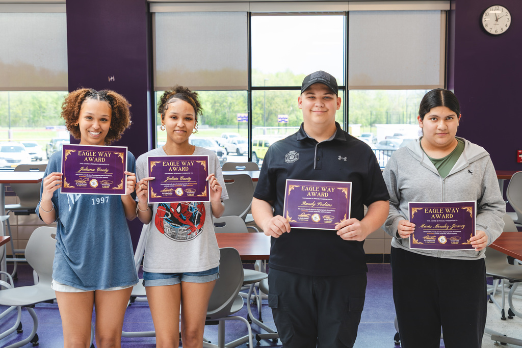 students posing with certificates of achievement