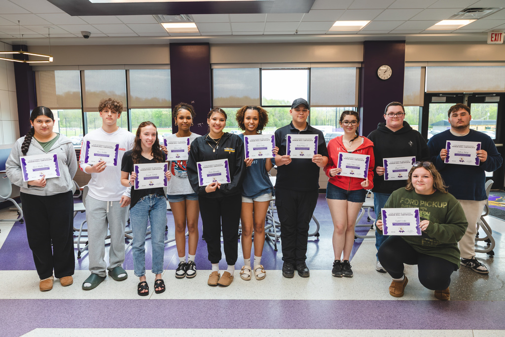 students posing with certificates of achievement