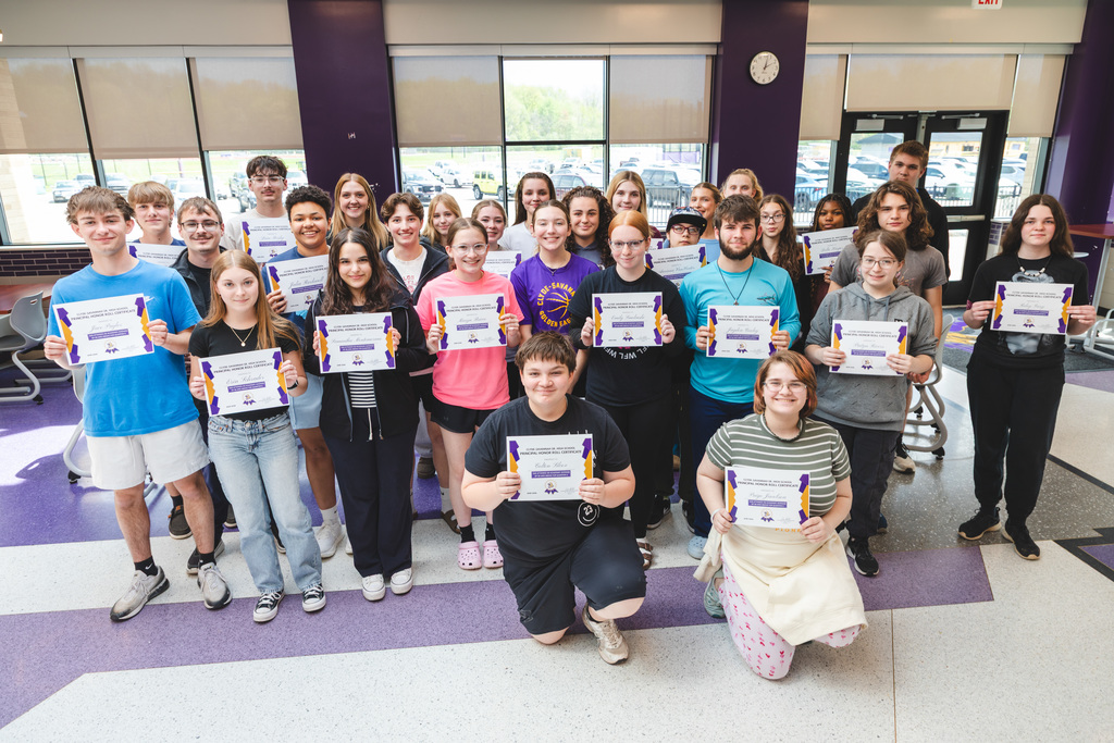 students posing with certificates of achievement