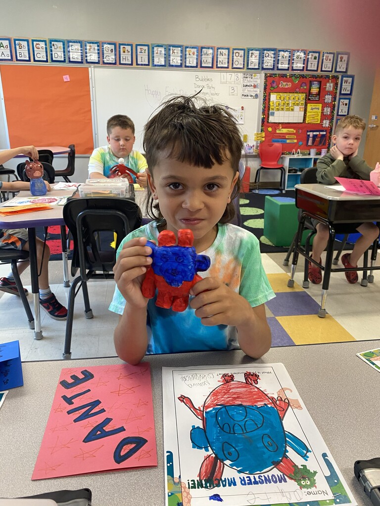 kindergartener holding clay monster