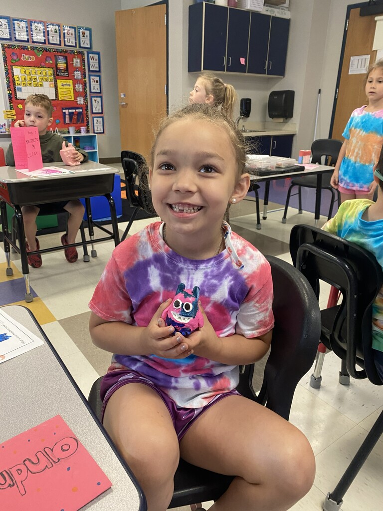 kindergartener holding clay monster