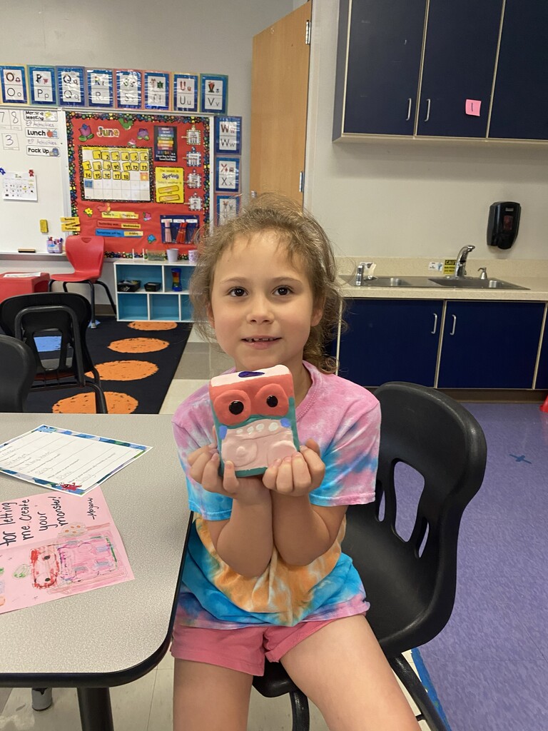 kindergartener holding clay monster