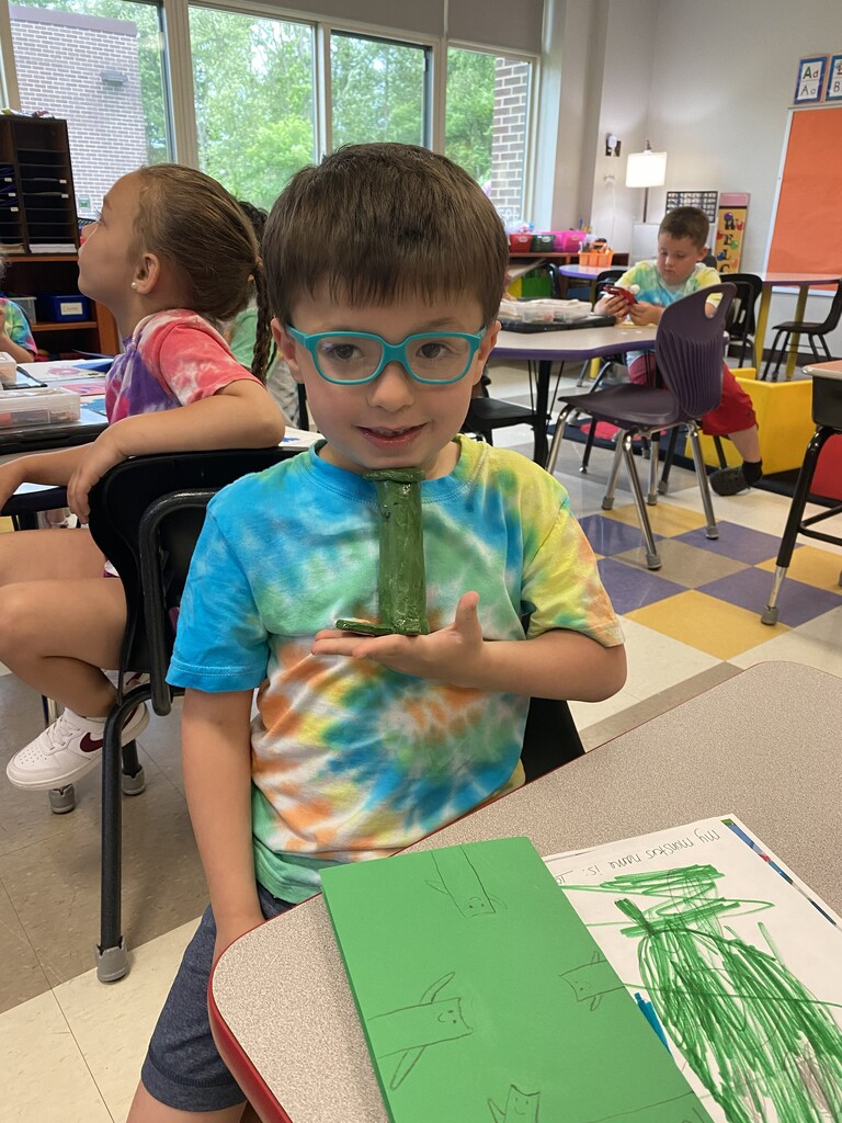 kindergartener holding clay monster