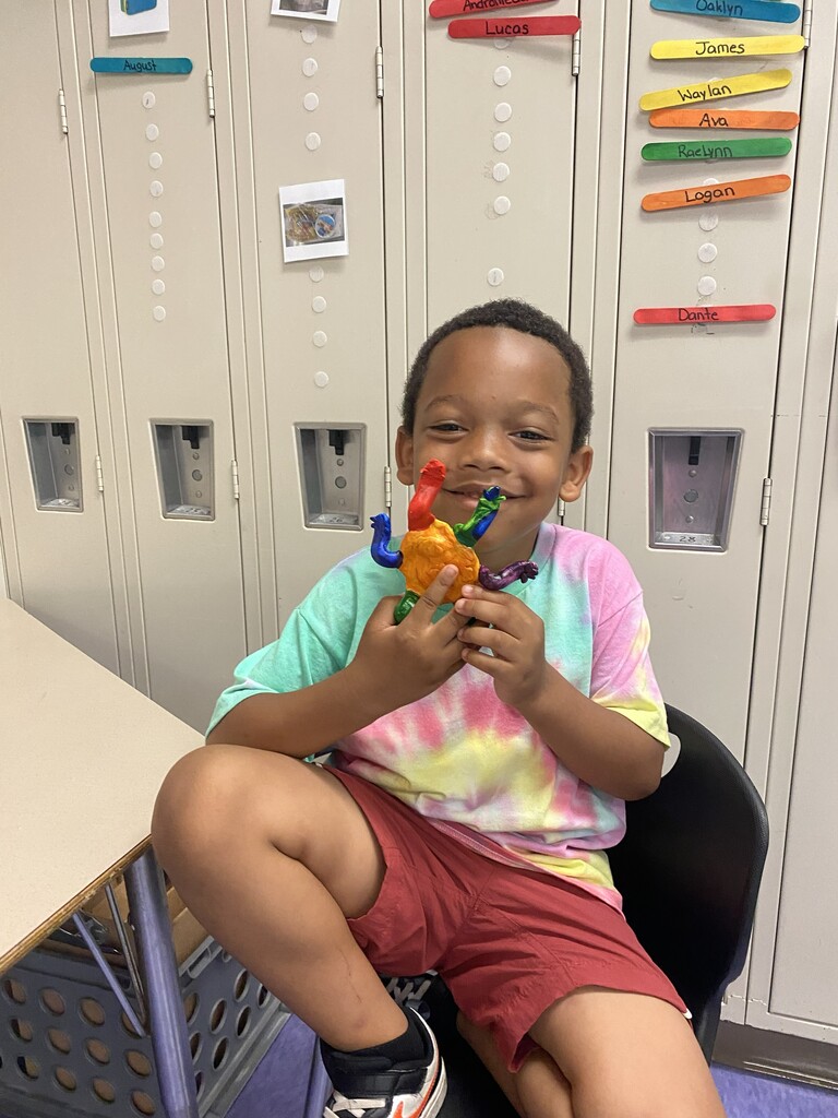 kindergartener holding clay monster